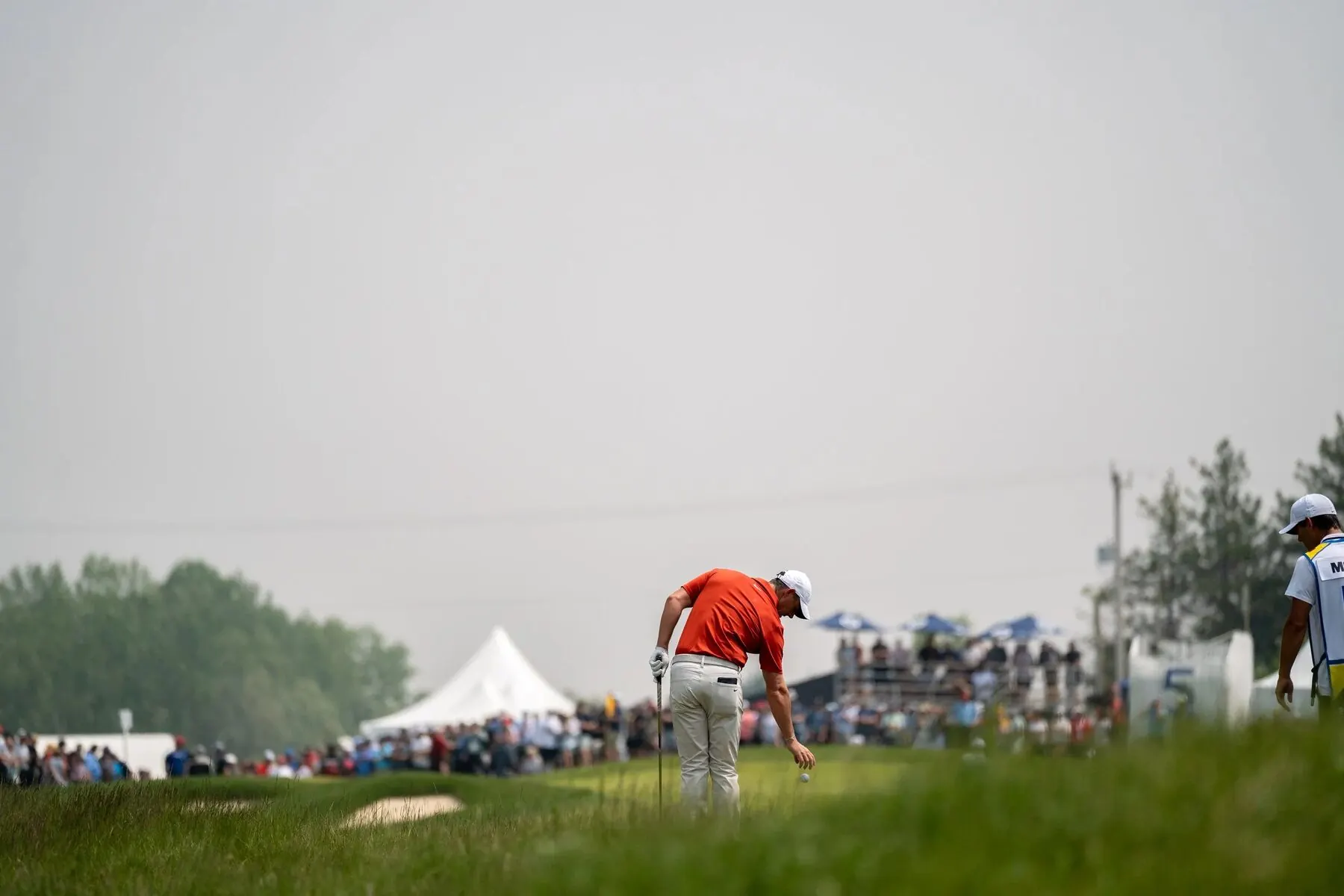 Golfer putting with grandstand crowd at the RBC Canadian Open