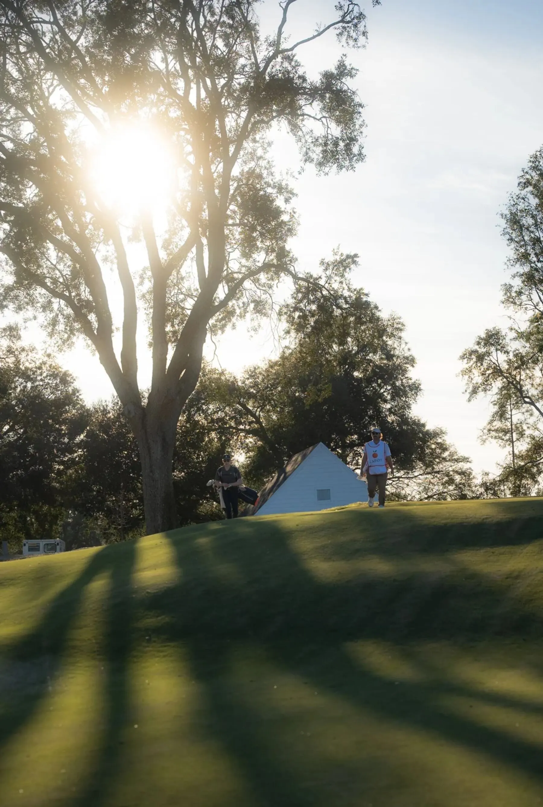 Golfers walking the course at sunrise
