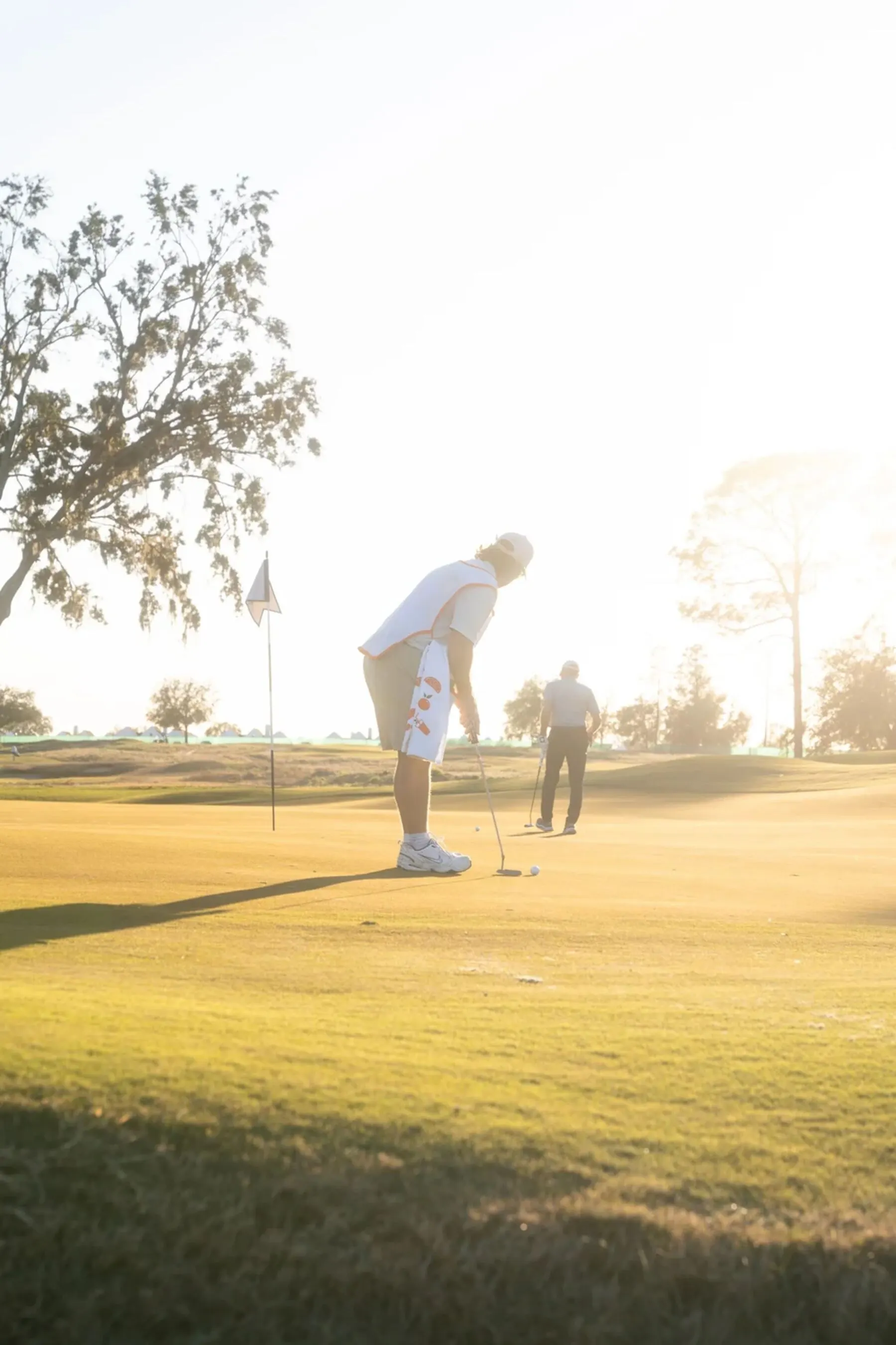 Golfers putting at sunset
