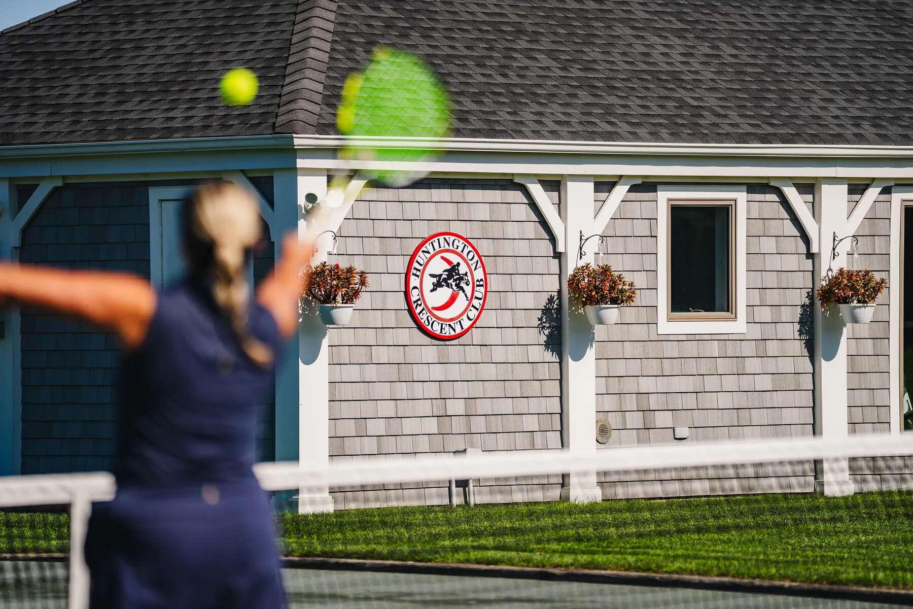 Tennis player on the grass court at Huntington Crescent Club