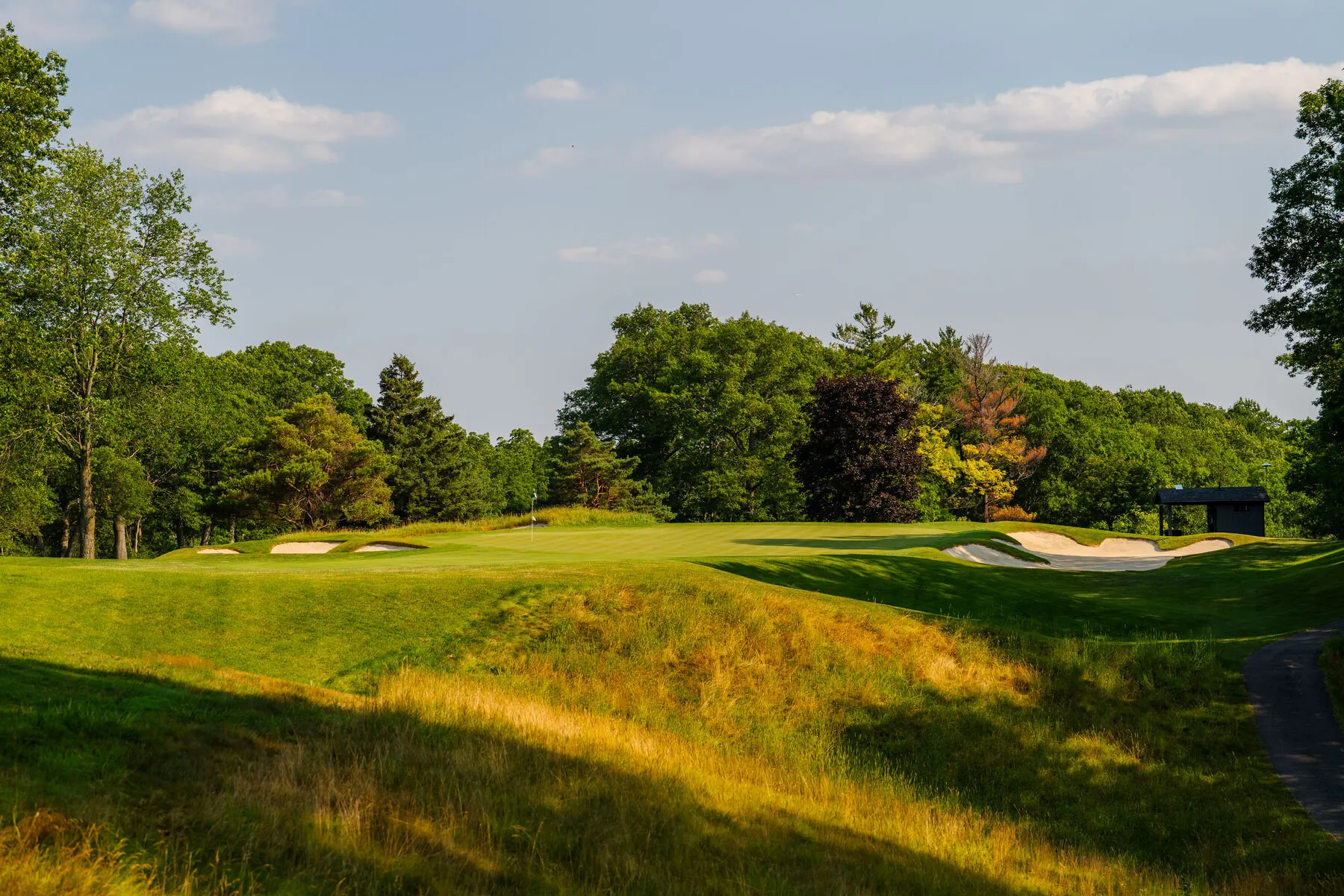 Green and bunkers framed by autumn trees
